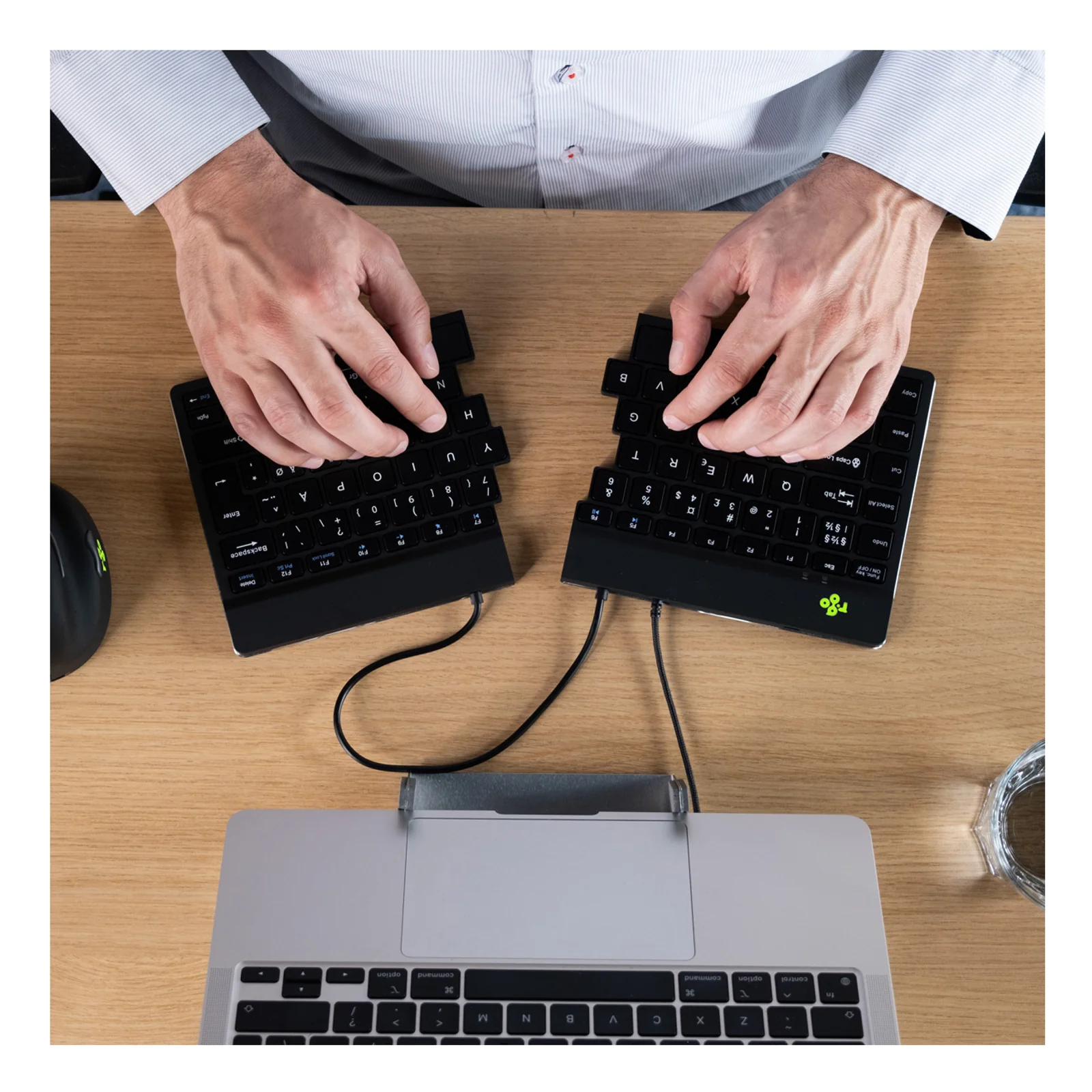 Personne utilisant le clavier R-Go Split Break v2 à un bureau avec ordinateur portable