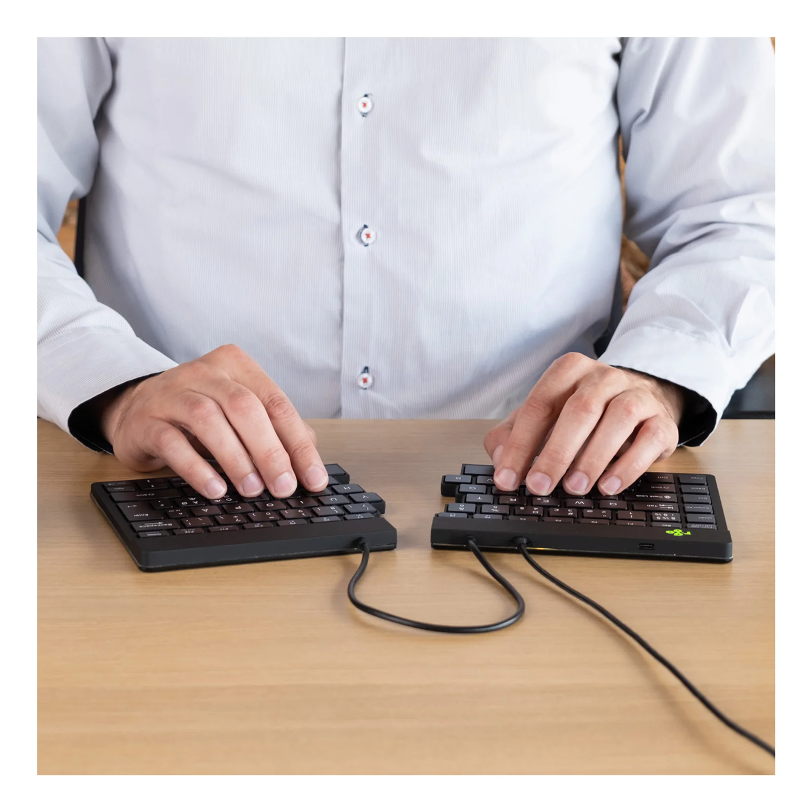 Personne en chemise utilisant le clavier divisé sur un bureau, vue de côté