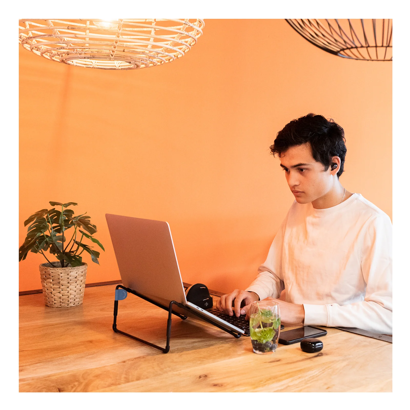 Homme en situation de travail avec laptop sur support R-Go Steel Travel, table en bois