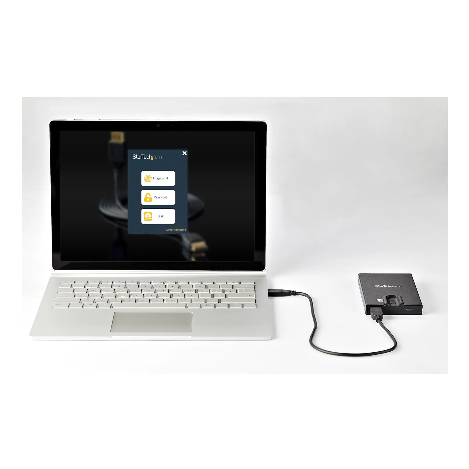 Boîtier connecté à un ordinateur portable affichant le logiciel de gestion avec les options empreinte digitale, mot de passe et disque