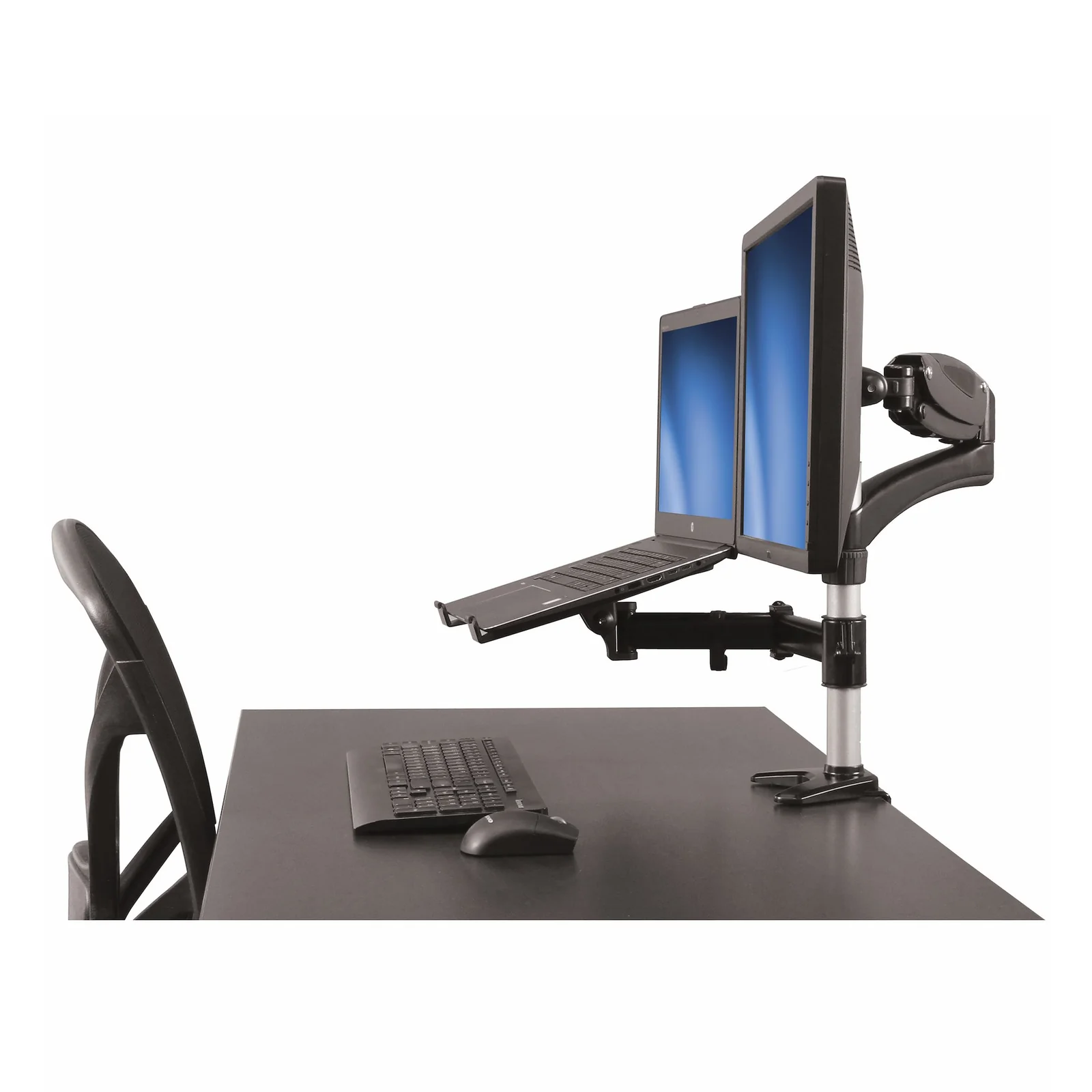 Bras articulé avec plateau laptop installé sur un bureau sombre, moniteur et ordinateur portable positionnés côte à côte, chaise de bureau visible à gauche