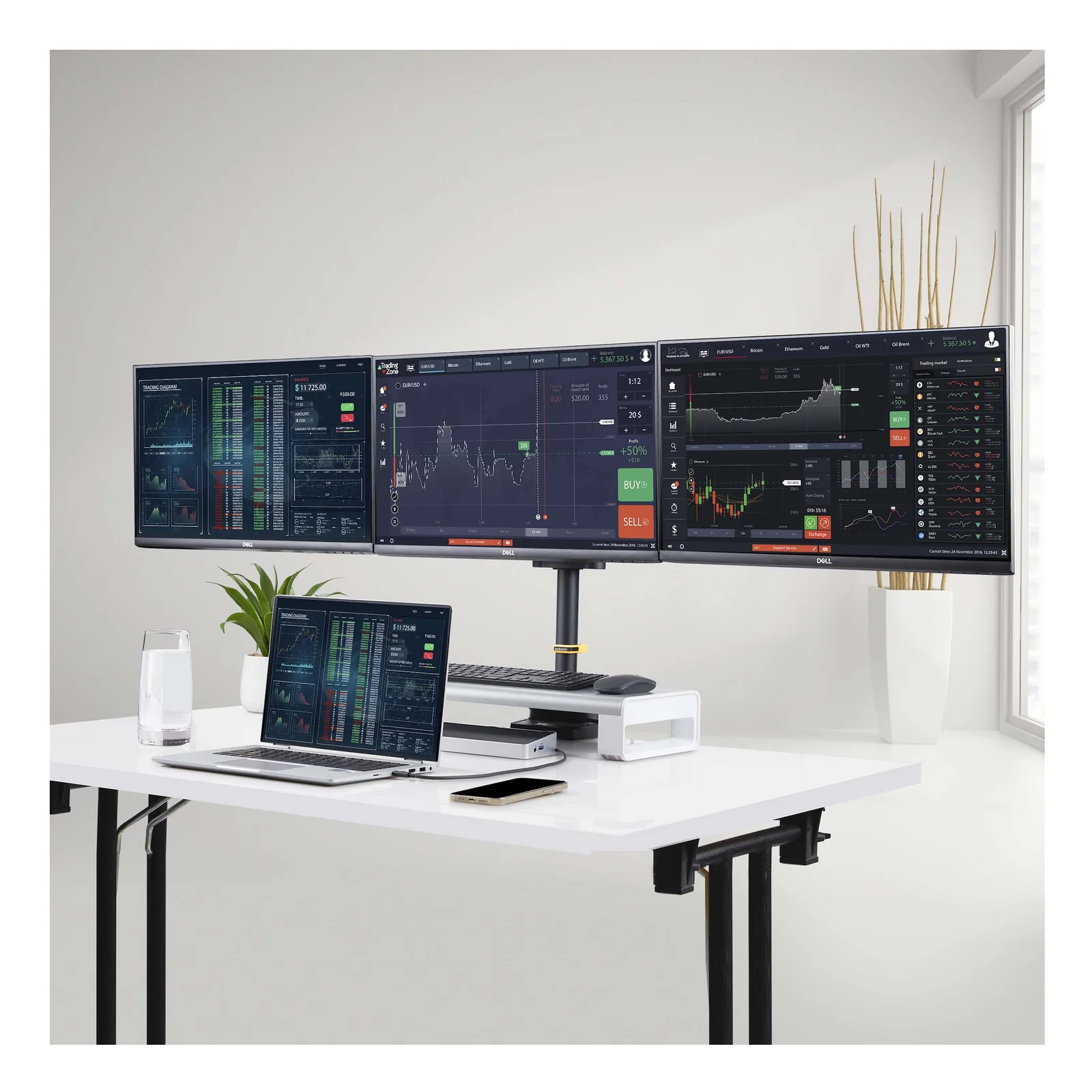 Mise en situation professionnelle avec 3 écrans Dell affichant des tableaux de bord de trading financier, support StarTech.com sur bureau blanc avec ordinateur portable.