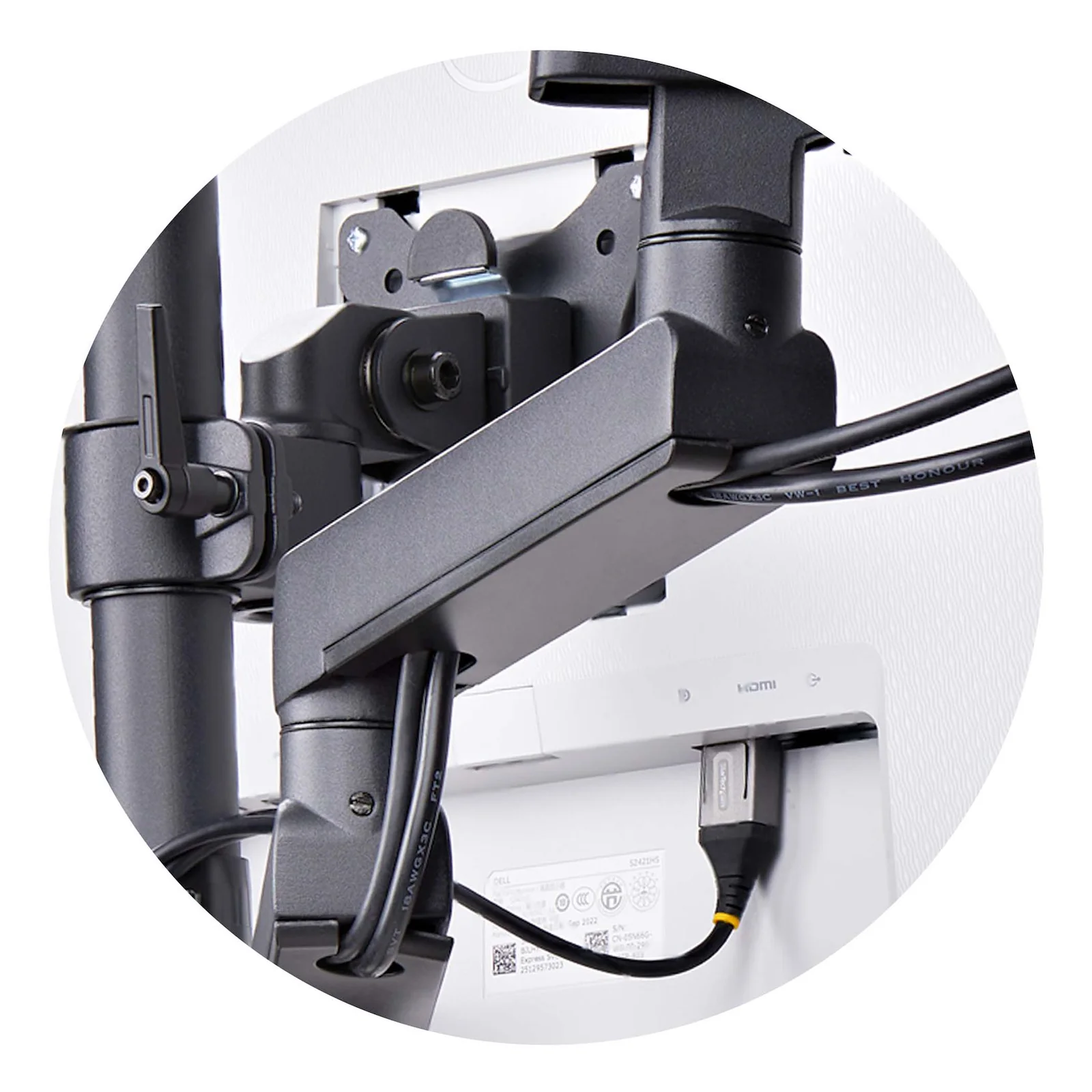 Vue en médaillon du passage de câbles intégré dans le bras StarTech.com, câble HDMI visible longeant le joint articulé à l'arrière d'un écran Dell.