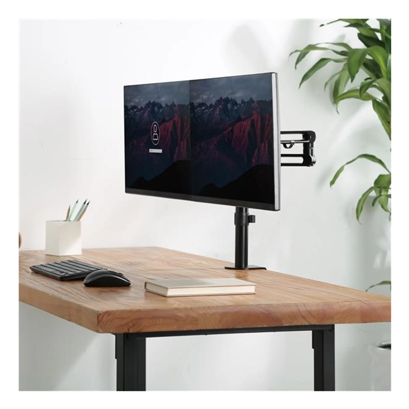Bras double écran installé sur un bureau en bois avec deux moniteurs côte à côte, clavier et souris visibles au premier plan