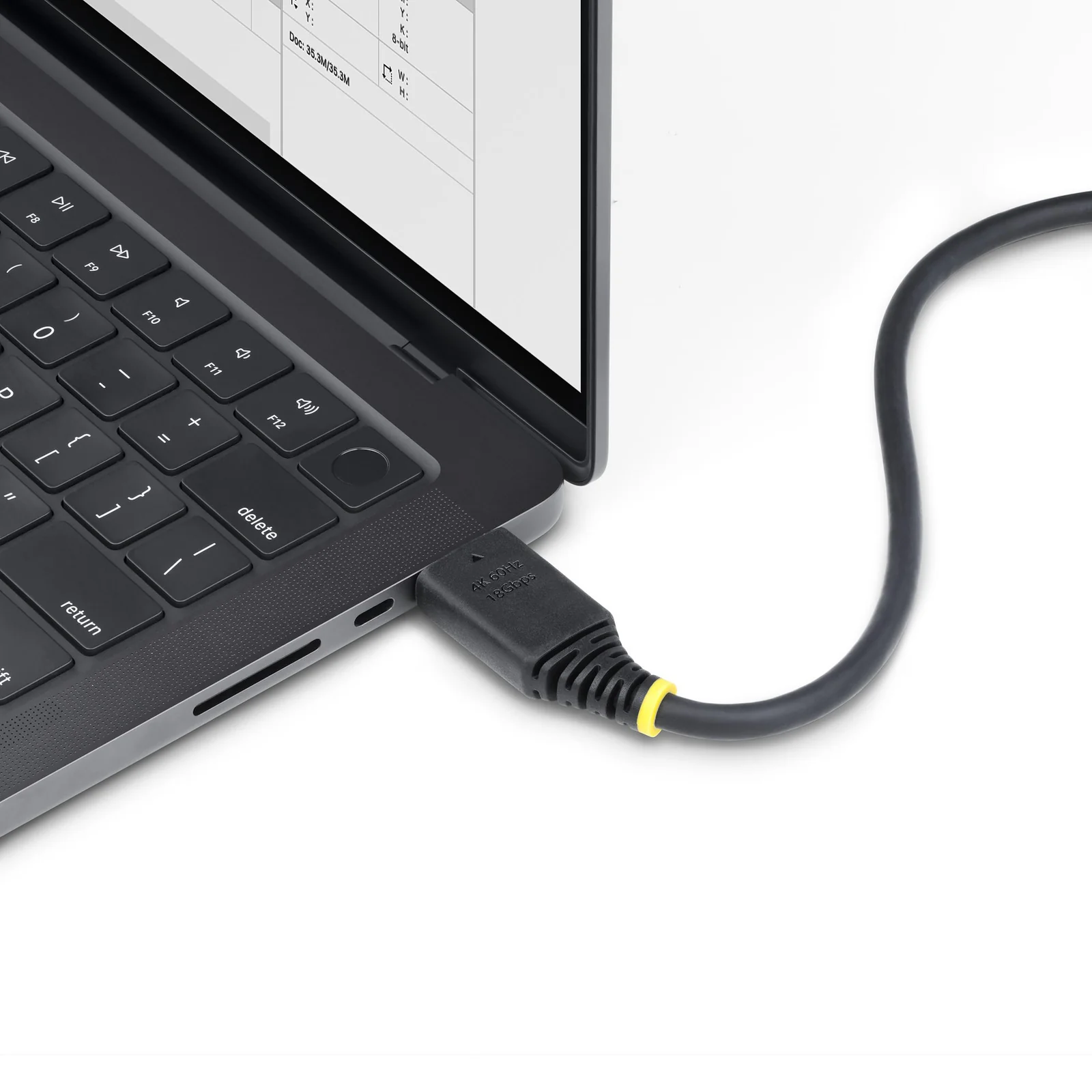 Connecteur HDMI noir à bague jaune branché sur le port HDMI d'un ordinateur portable, câble gris foncé partant vers la droite