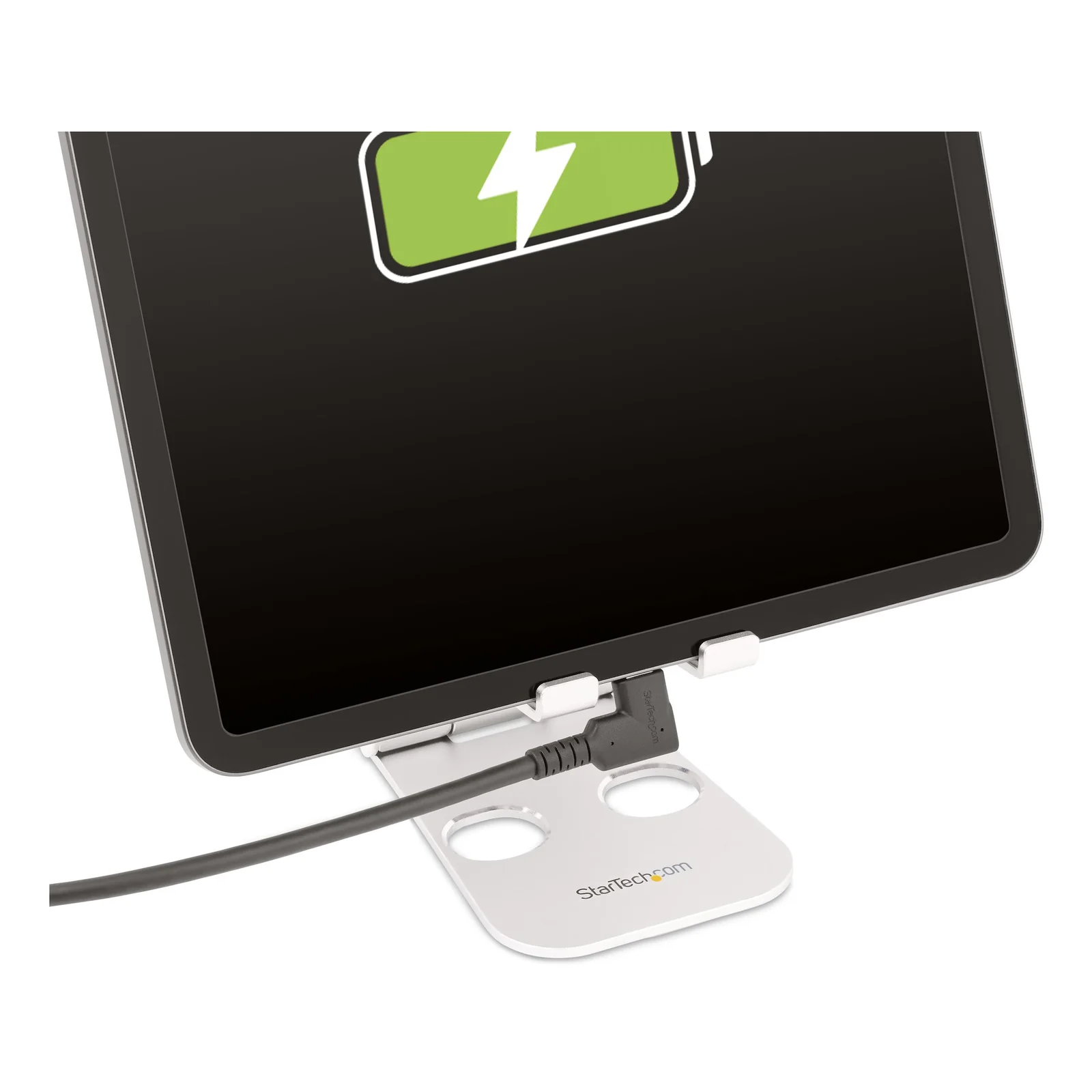 Connecteur USB-C coudé à 90 degrés branché sur le port d'une tablette posée sur un support blanc, écran affichant une icône de charge