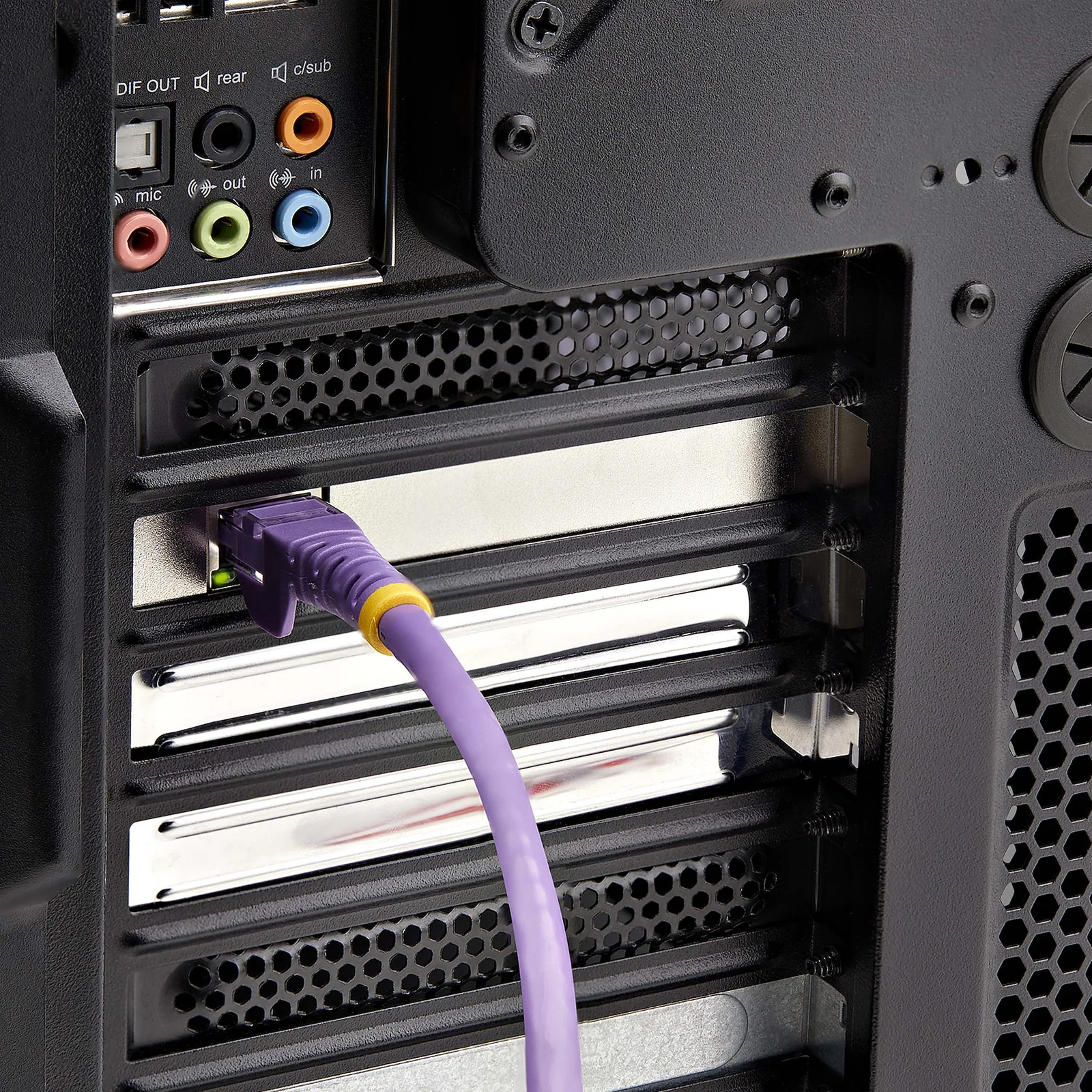 Câble réseau RJ45 violet branché sur le port de la carte réseau installée à l'arrière d'un boîtier PC noir