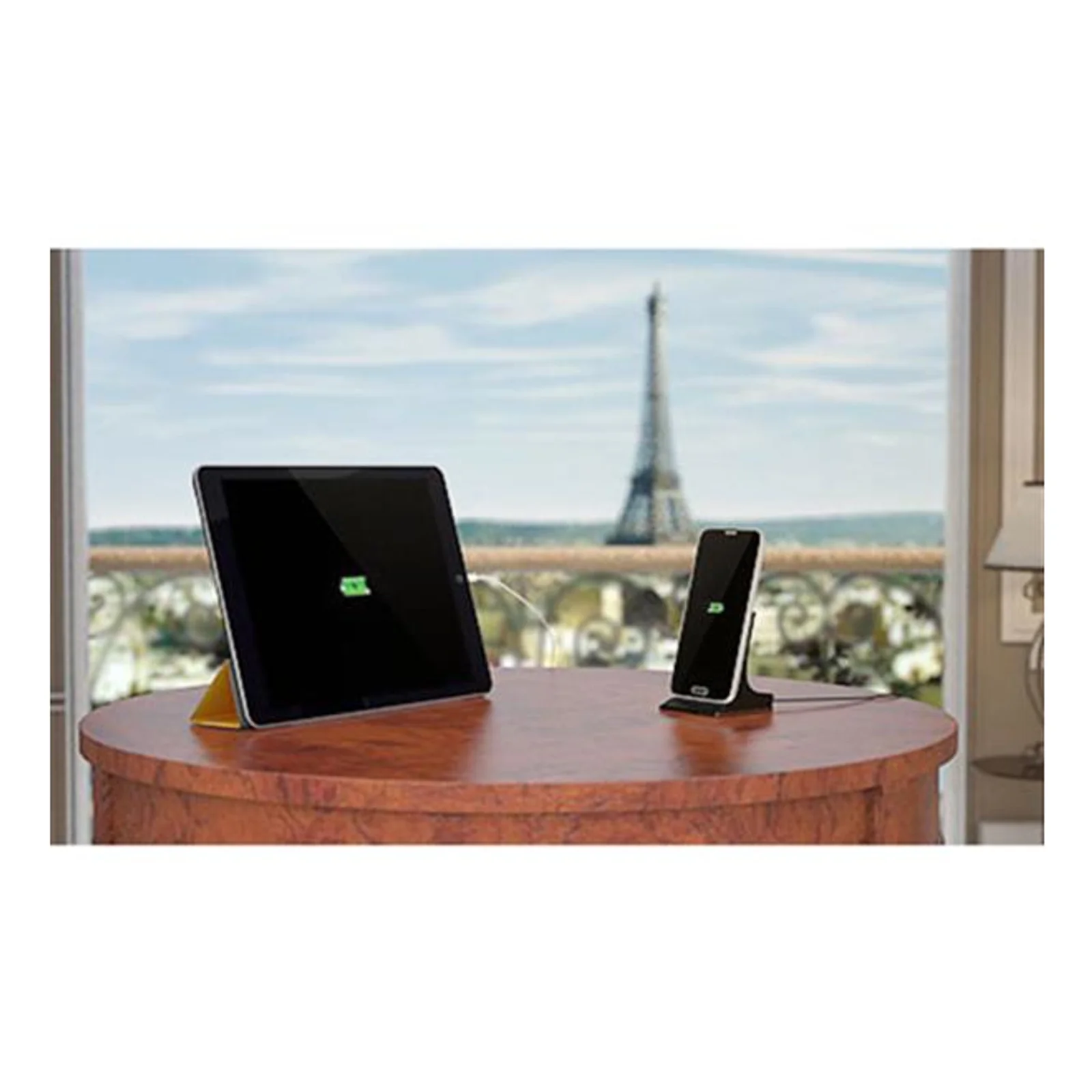 Mise en situation du chargeur USB2PACWH, tablette et smartphone en charge sur une table, Tour Eiffel visible par la fenêtre