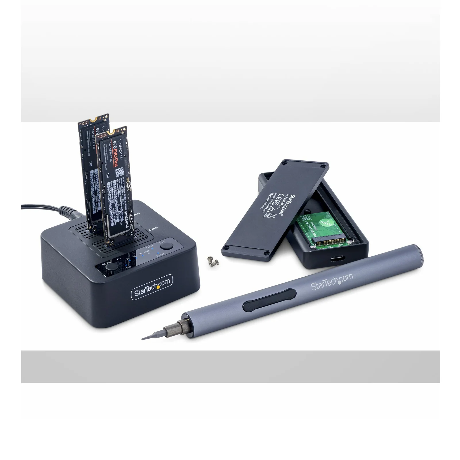 Station de duplication M.2 NVMe avec deux SSD insérés en mode clonage, boîtier M.2 USB ouvert et tournevis électrique posés à côté