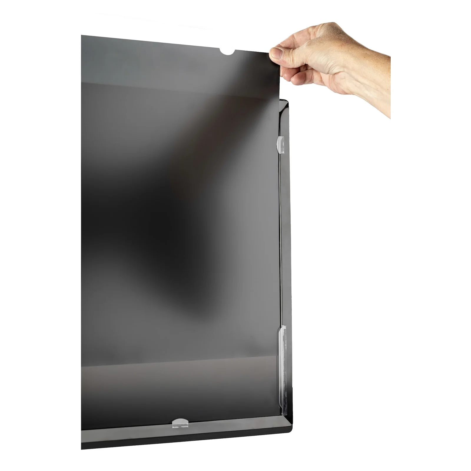 Main tenant un filtre de confidentialité rectangulaire gris foncé en position verticale, avec des languettes de fixation transparentes visibles sur le bord droit