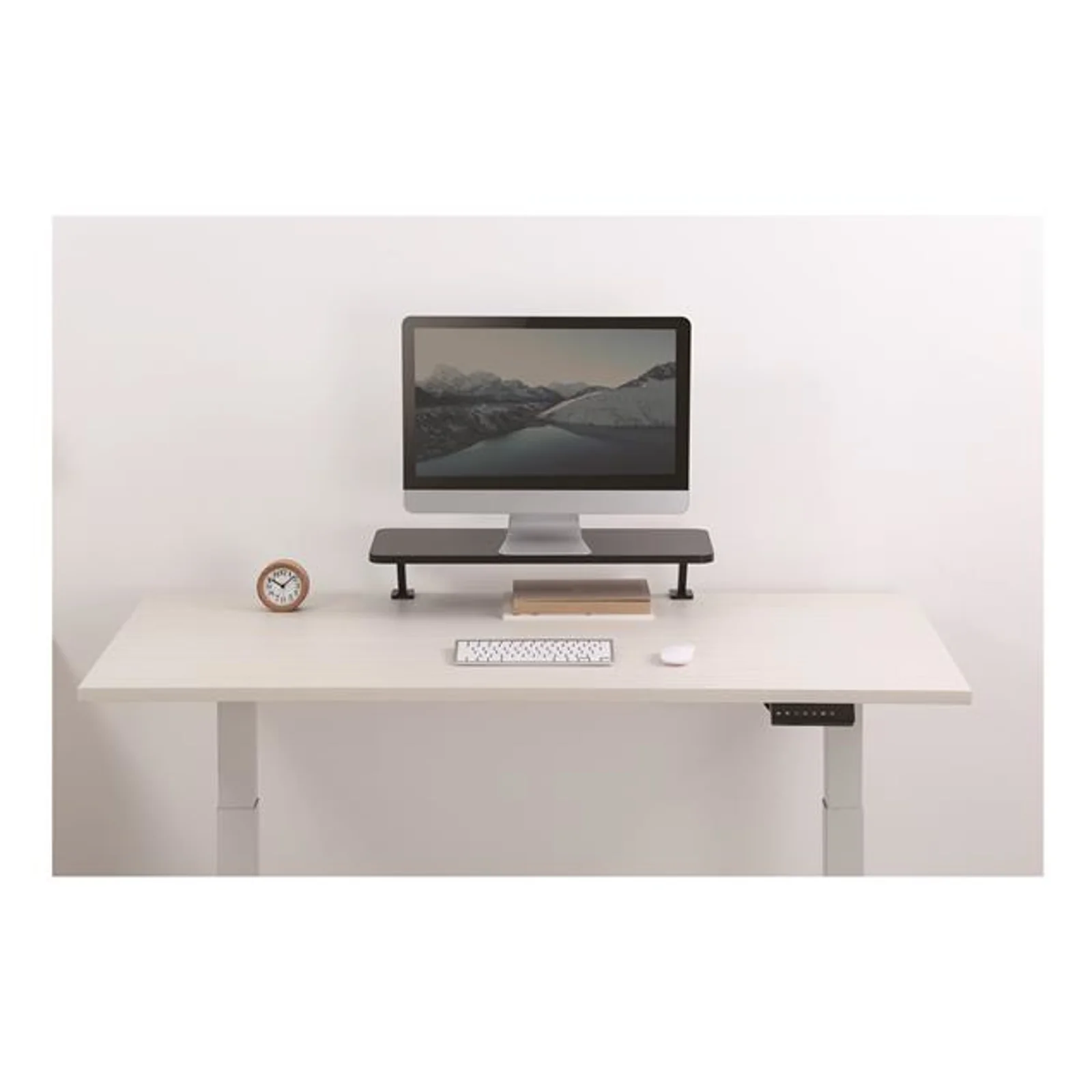 Rehausseur installé sur un bureau blanc réglable en hauteur, supportant un écran avec clavier et souris en dessous