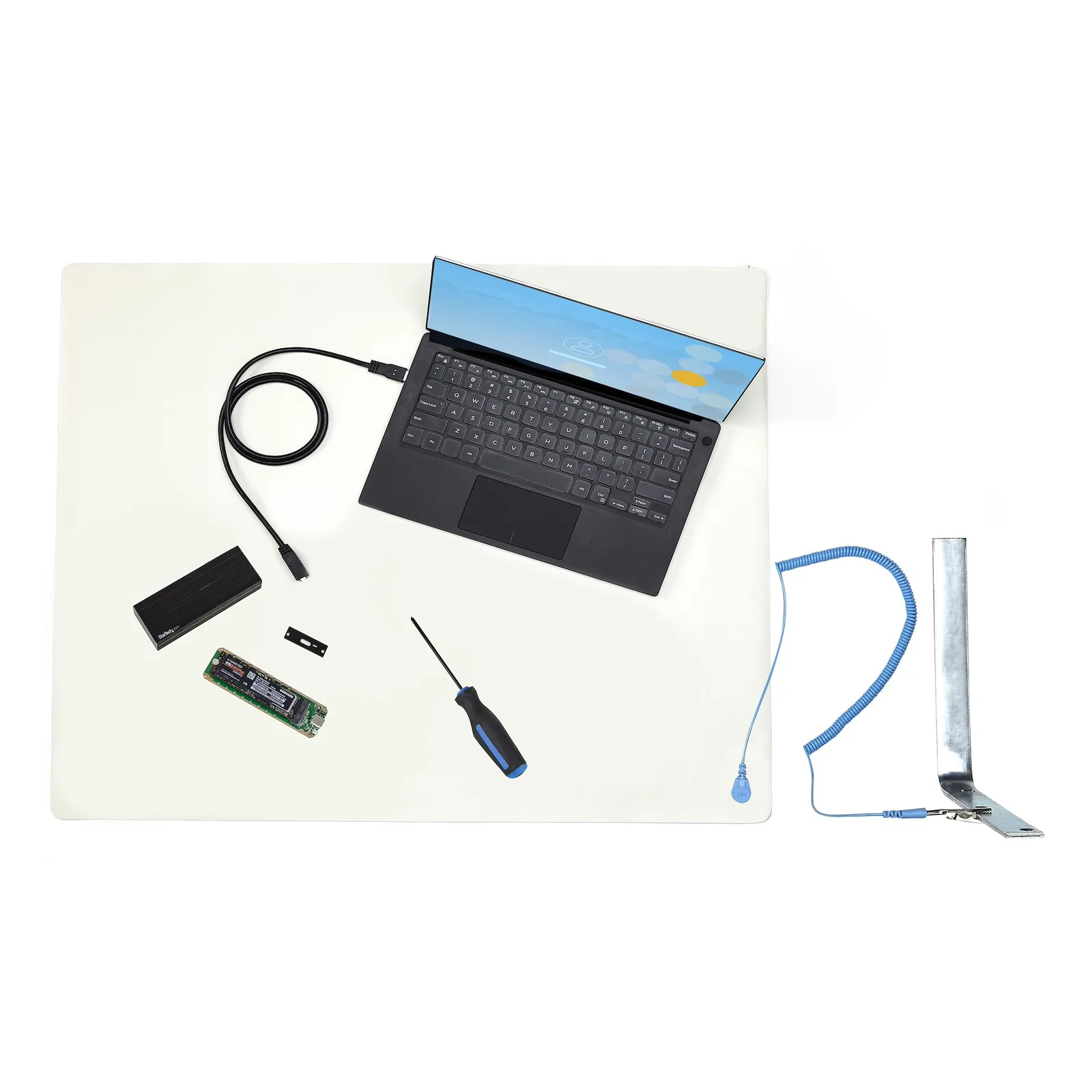 Tapis antistatique ESD sur bureau avec laptop, SSD M.2 et boitier NVMe, câble de terre sur support