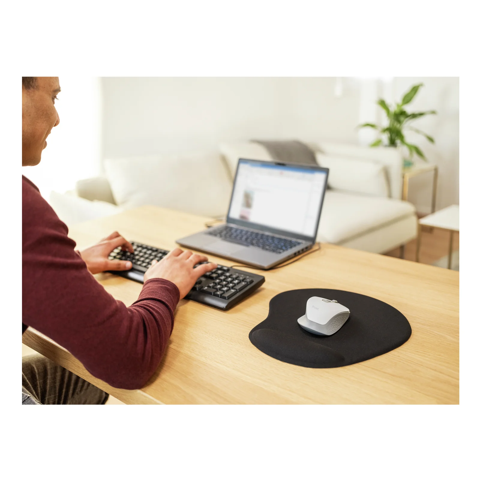 Personne devant ordinateur portable, tapis de souris noir ovale utilisé sur un bureau
