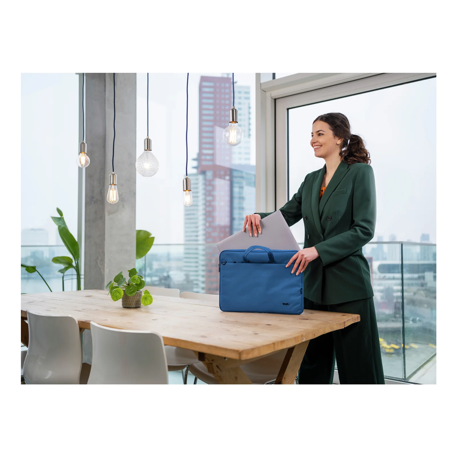 Femme en tailleur saisissant la Trust Bologna bleue depuis une table de bureau