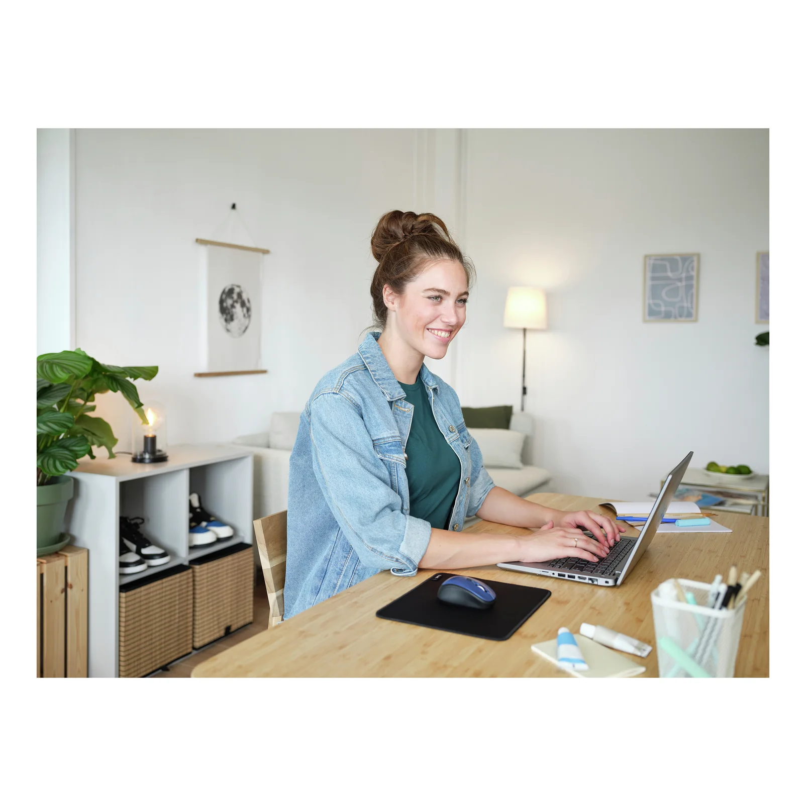 Femme travaillant sur ordinateur portable à un bureau, tapis Trust Boye Noir posé devant