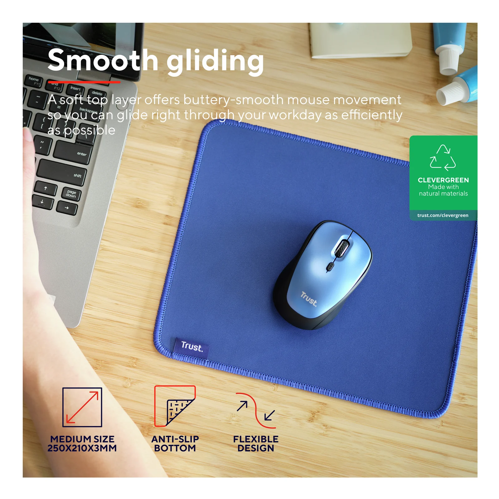 Tapis Trust Boye bleu avec souris sur bureau en bois, pictogrammes eco et anti-glisse visibles