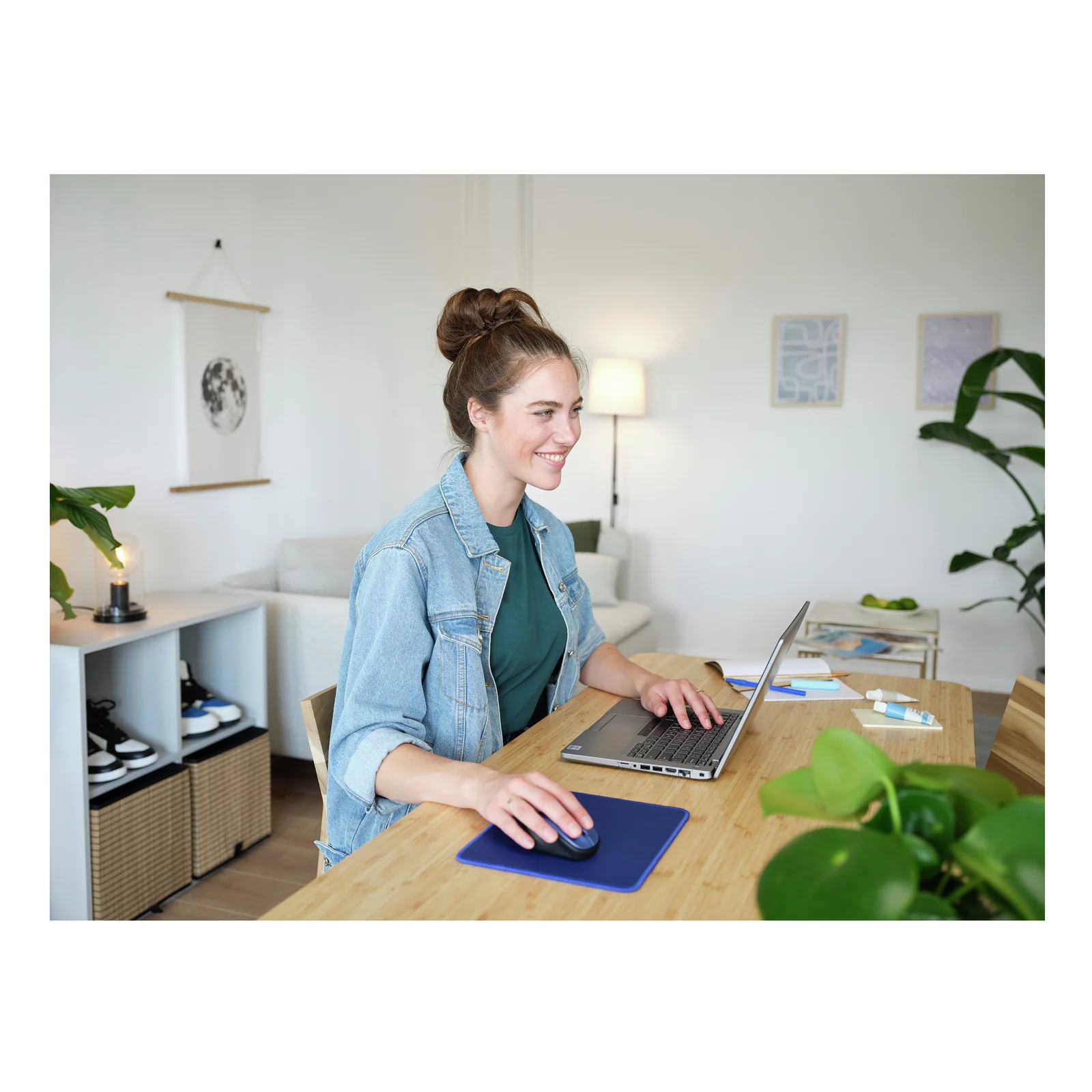 Femme travaillant à un bureau avec laptop et tapis de souris Trust Boye bleu