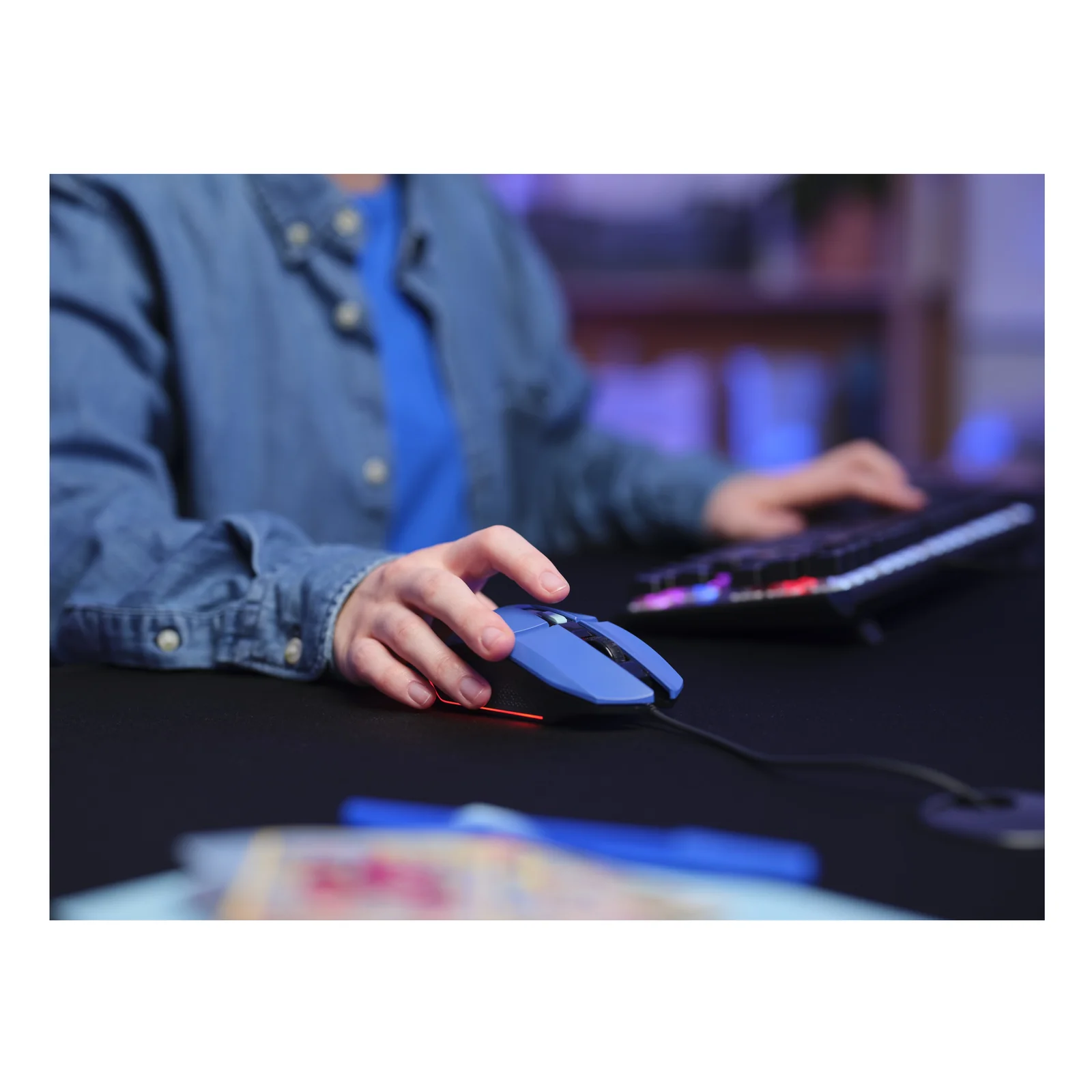 Souris gaming bleue Trust Felox utilisée sur un bureau, main visible sur la souris