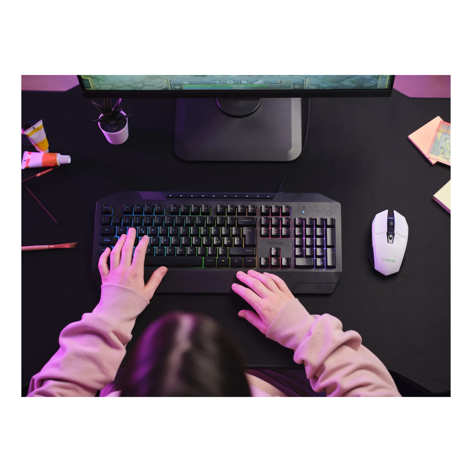 Souris gaming Trust GXT 110 Felox blanche posée sur bureau à côté d'un clavier, vue de dessus en situation