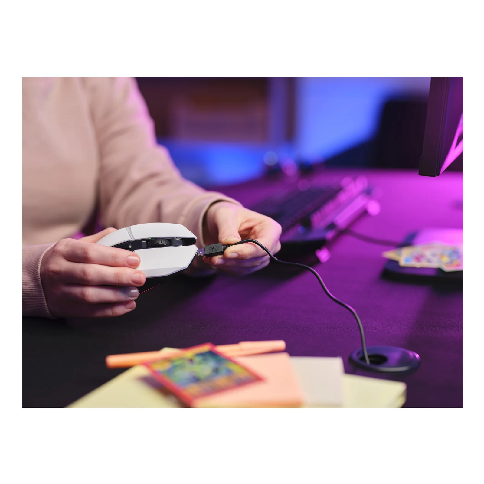 Main branchant un câble USB sur la souris Trust GXT 110 Felox pour la recharge