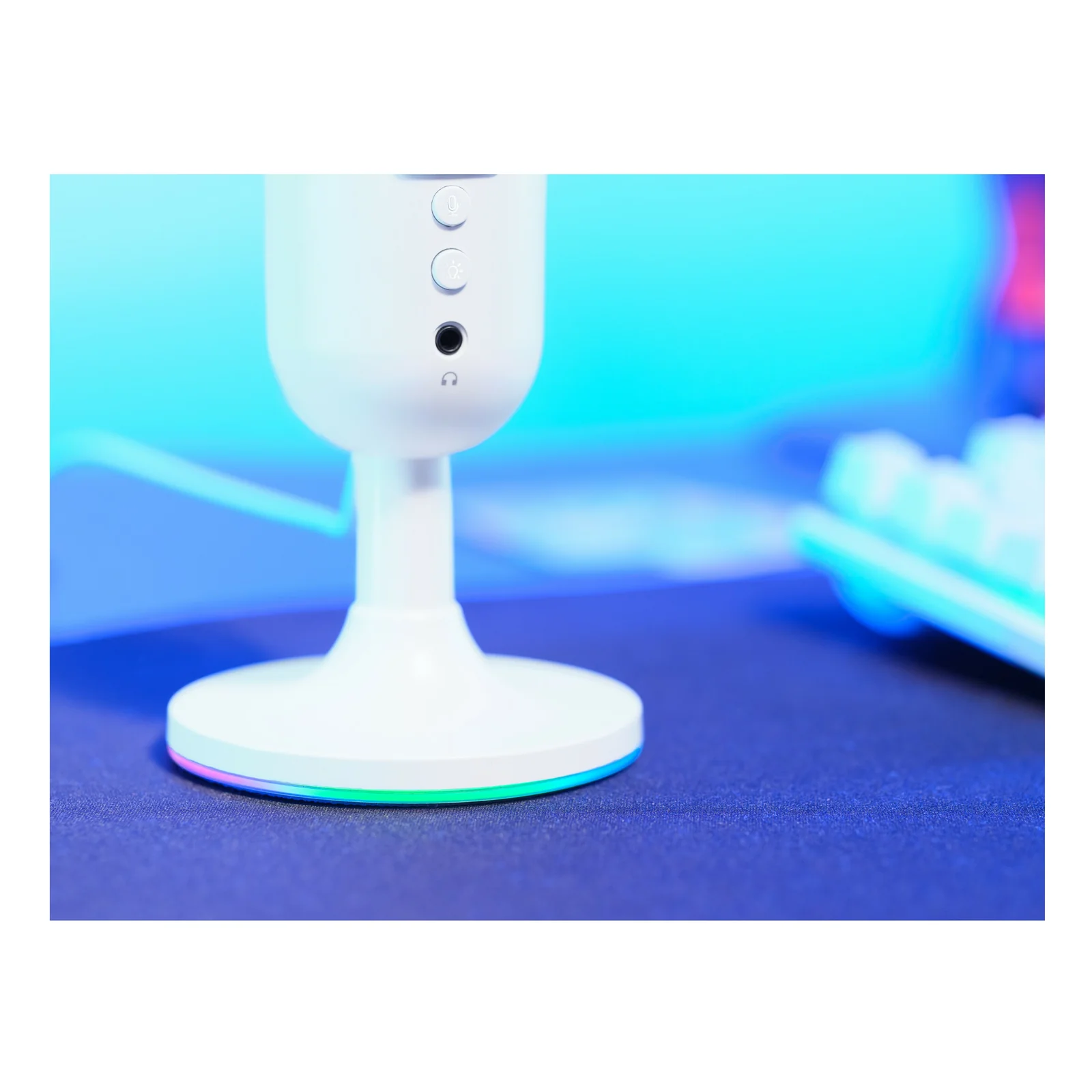 Plan serré sur la base du micro Yunix, éclairage RGB vert-bleu allumé posé sur bureau