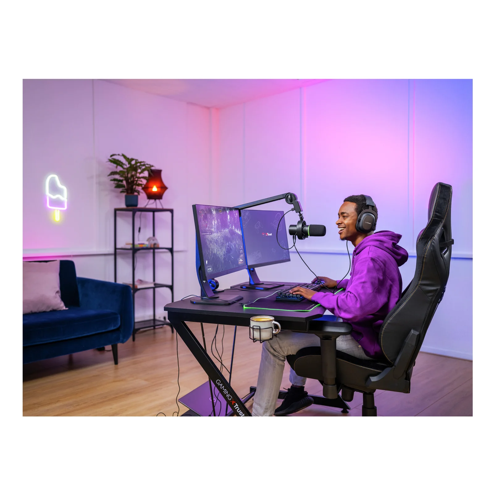 Homme en setup streaming gaming avec micro Trust GXT 255+ Onyx, éclairage violet et rose