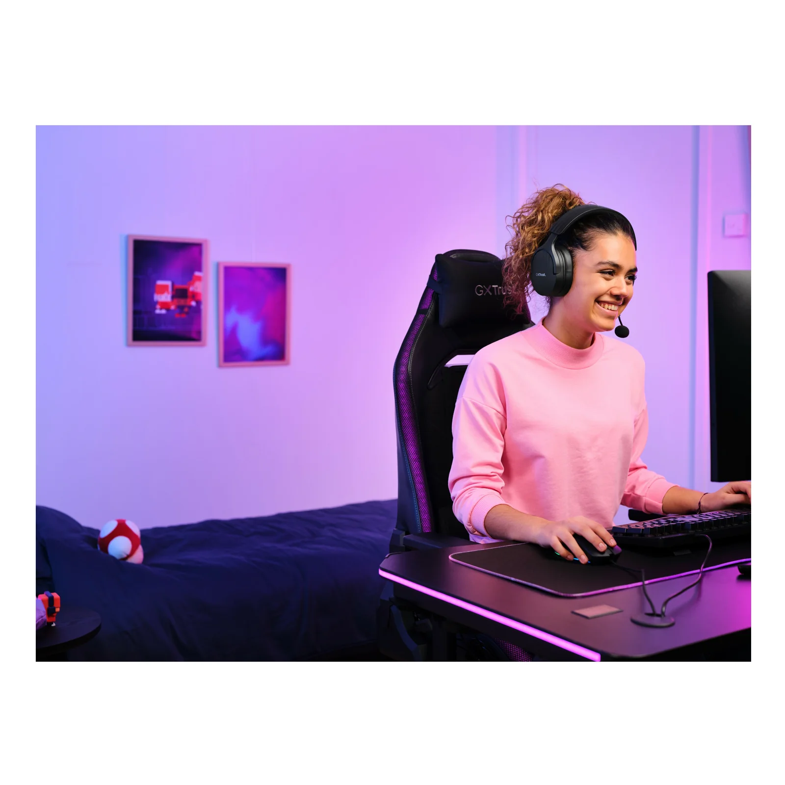 Joueuse souriante portant le Trust GXT 491 Fayzo, pièce lumineuse
