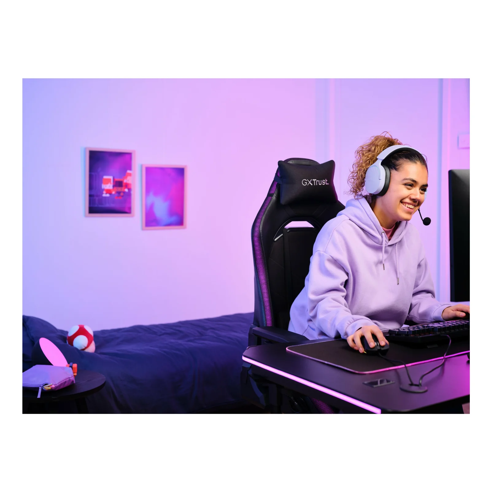 Lifestyle, femme portant un casque Trust GXT 491P FAYZO blanc, assise dans un fauteuil gaming