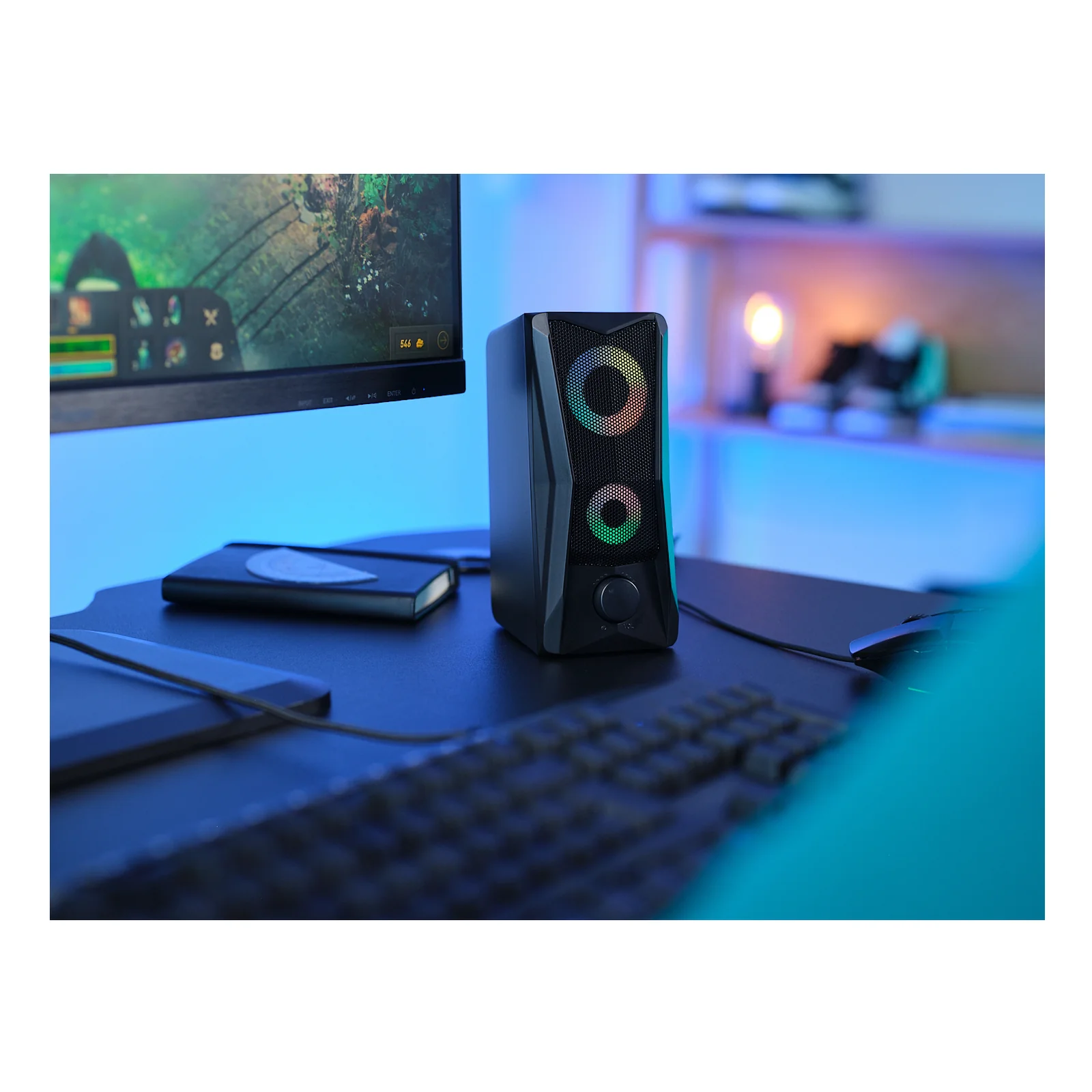 Vue rapprochée des enceintes Trust GXT 606 JAVV sur bureau avec clavier, éclairage ambiant
