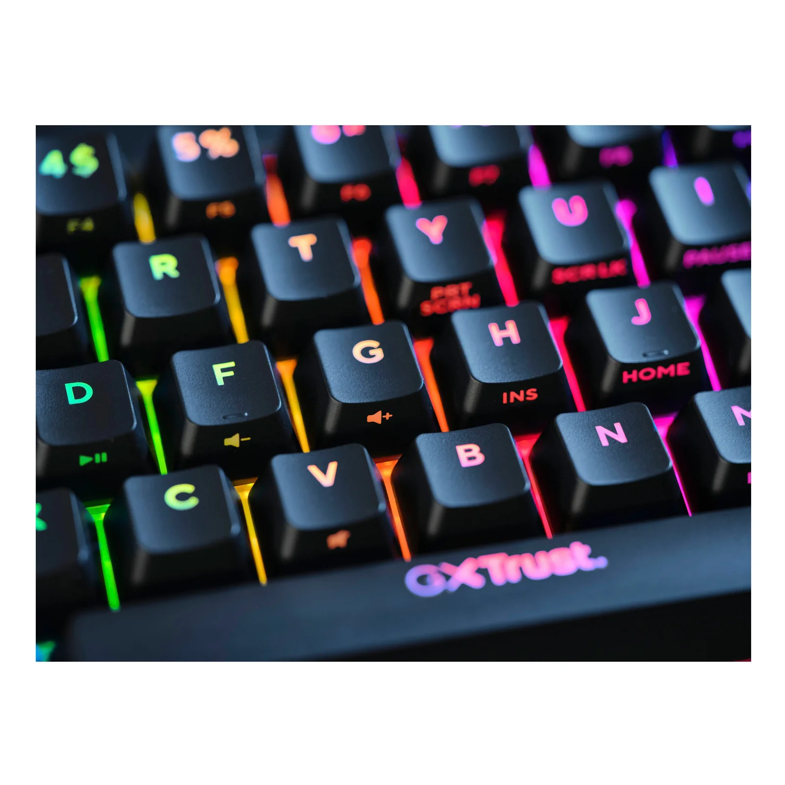 Gros plan sur les touches AZERTY avec éclairage RGB multicolore, logo Trust visible en bas à droite