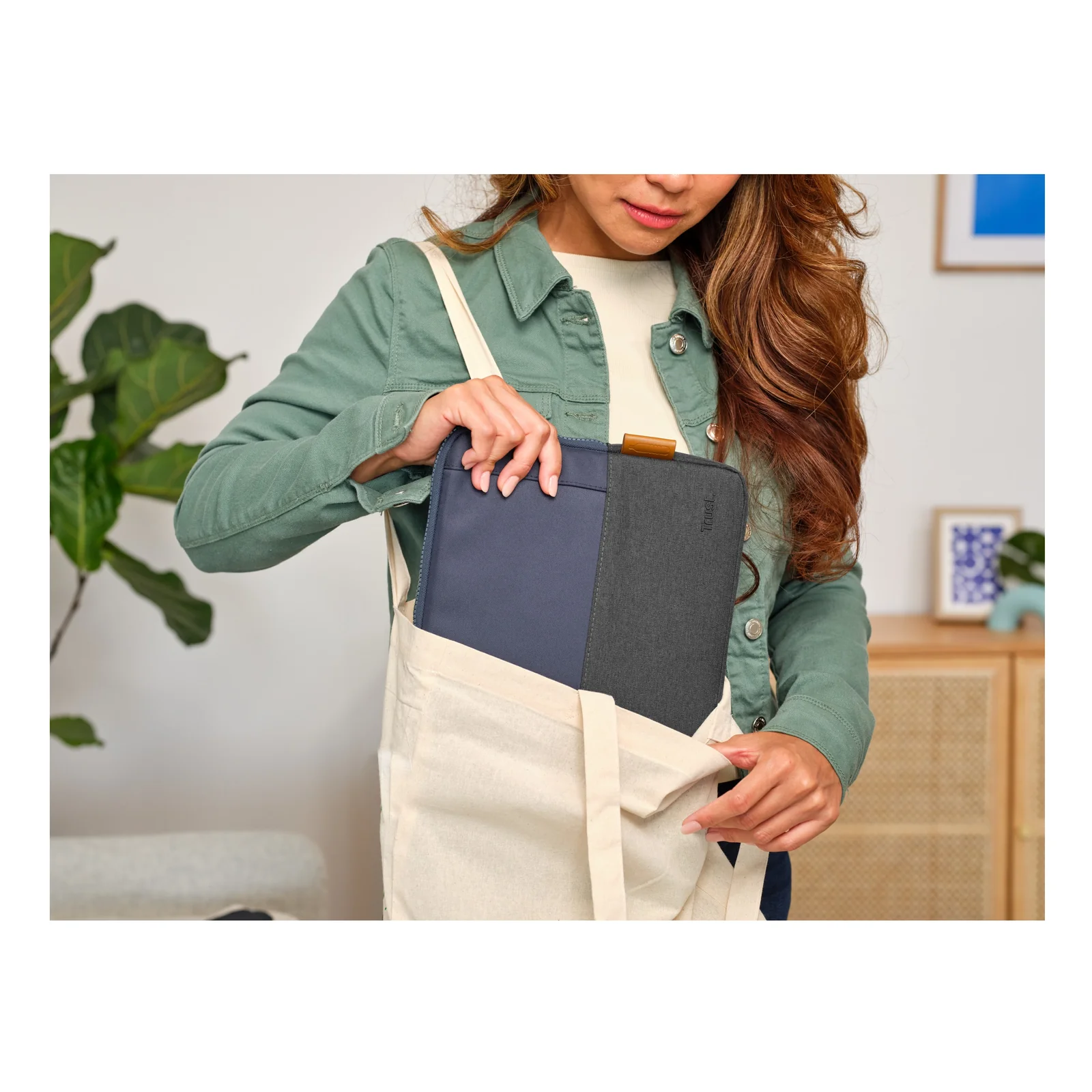 Femme portant la housse Trust Lisboa 25123 glissée dans un tote bag blanc