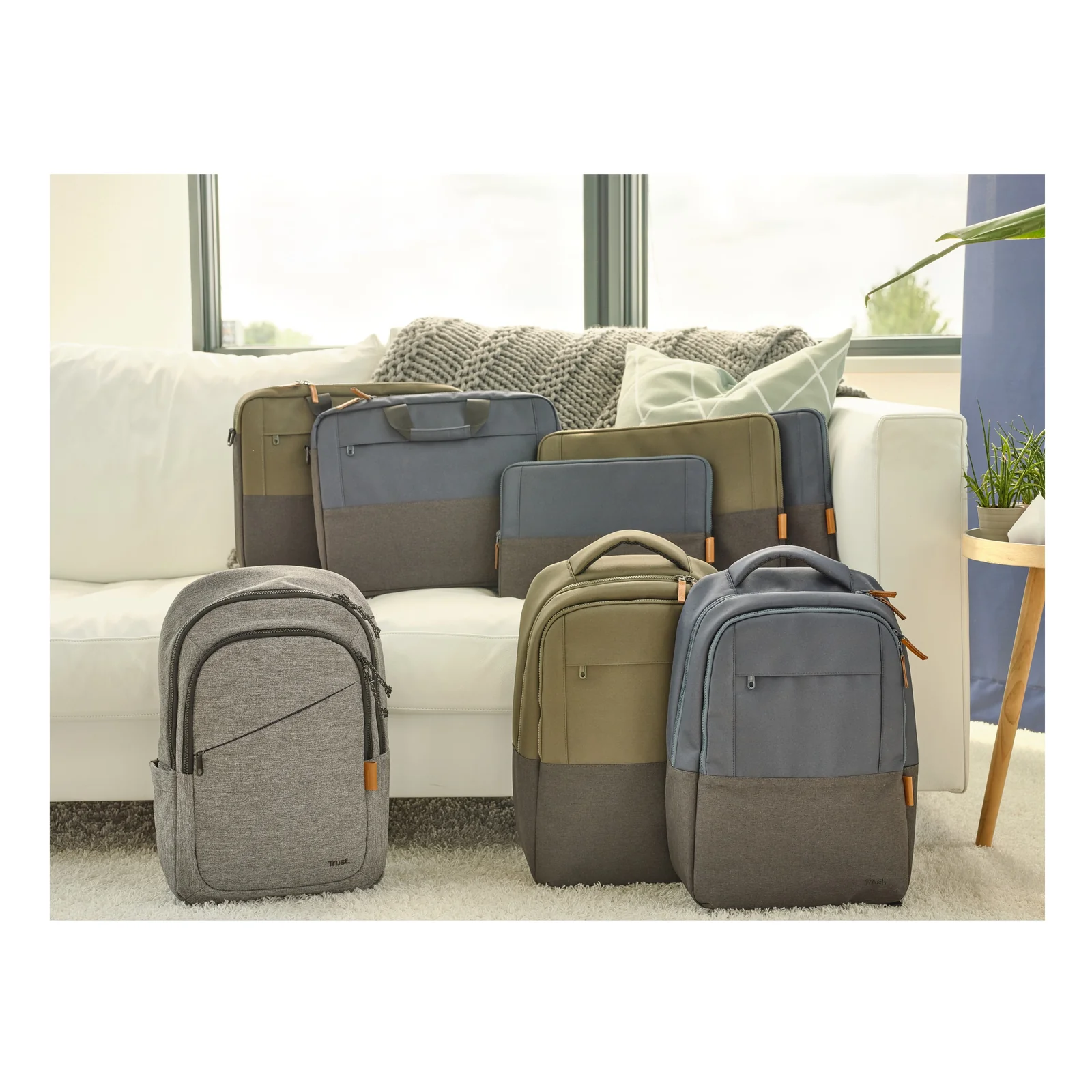 Gamme Trust Lisboa, sac à dos et housses posés sur un canapé, coloris gris et kaki