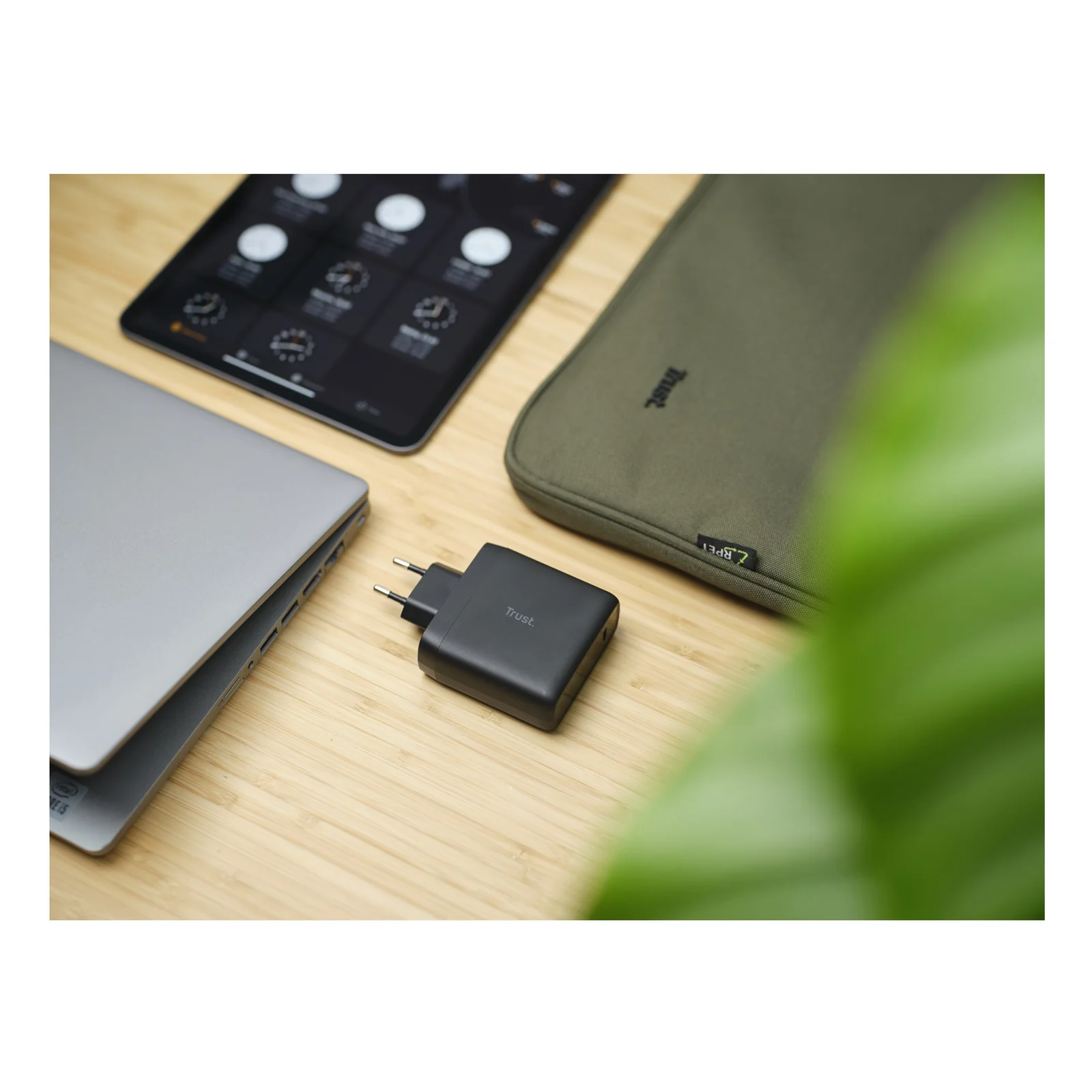 Chargeur Trust Maxo posé sur un bureau avec ordinateur portable et plante