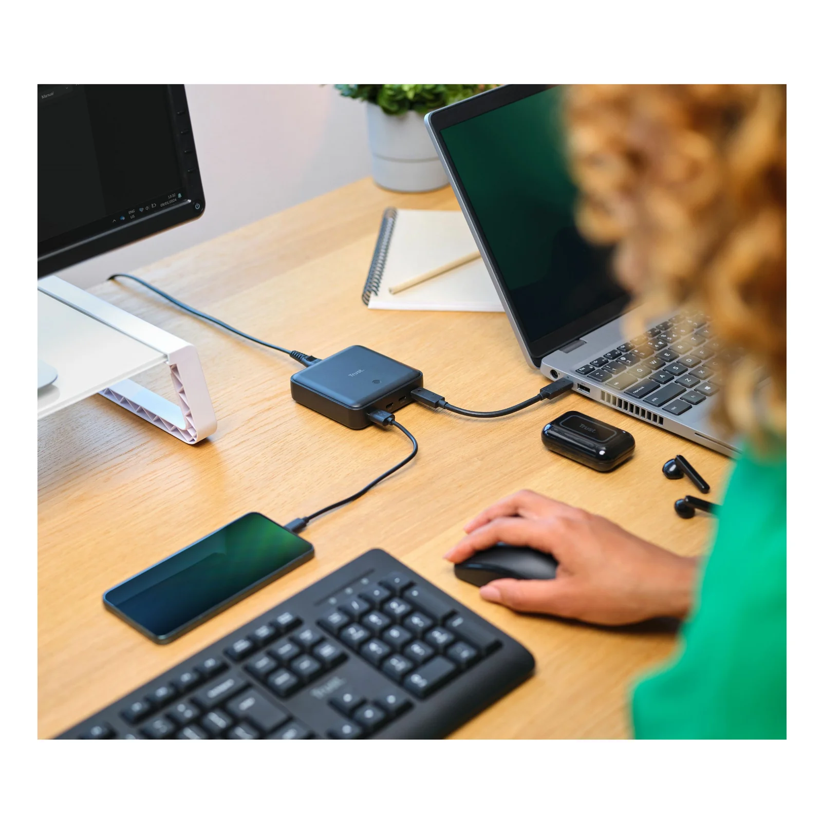 Femme à son bureau avec clavier, souris et Trust Maxo en cours de charge, appareils connectés