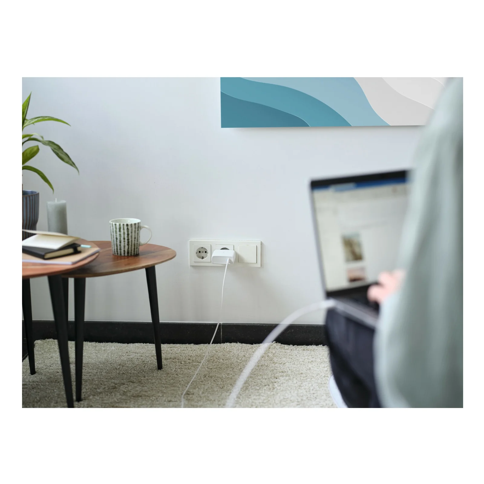 Photo d'ambiance, personne connectant un câble USB-C dans une prise murale, bureau en arrière-plan