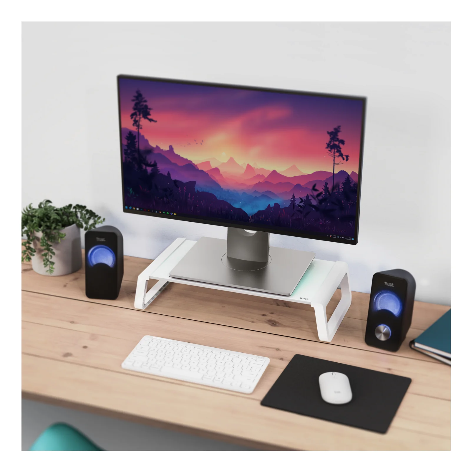 Support moniteur blanc sur bureau en bois, écran et enceintes, clavier et souris