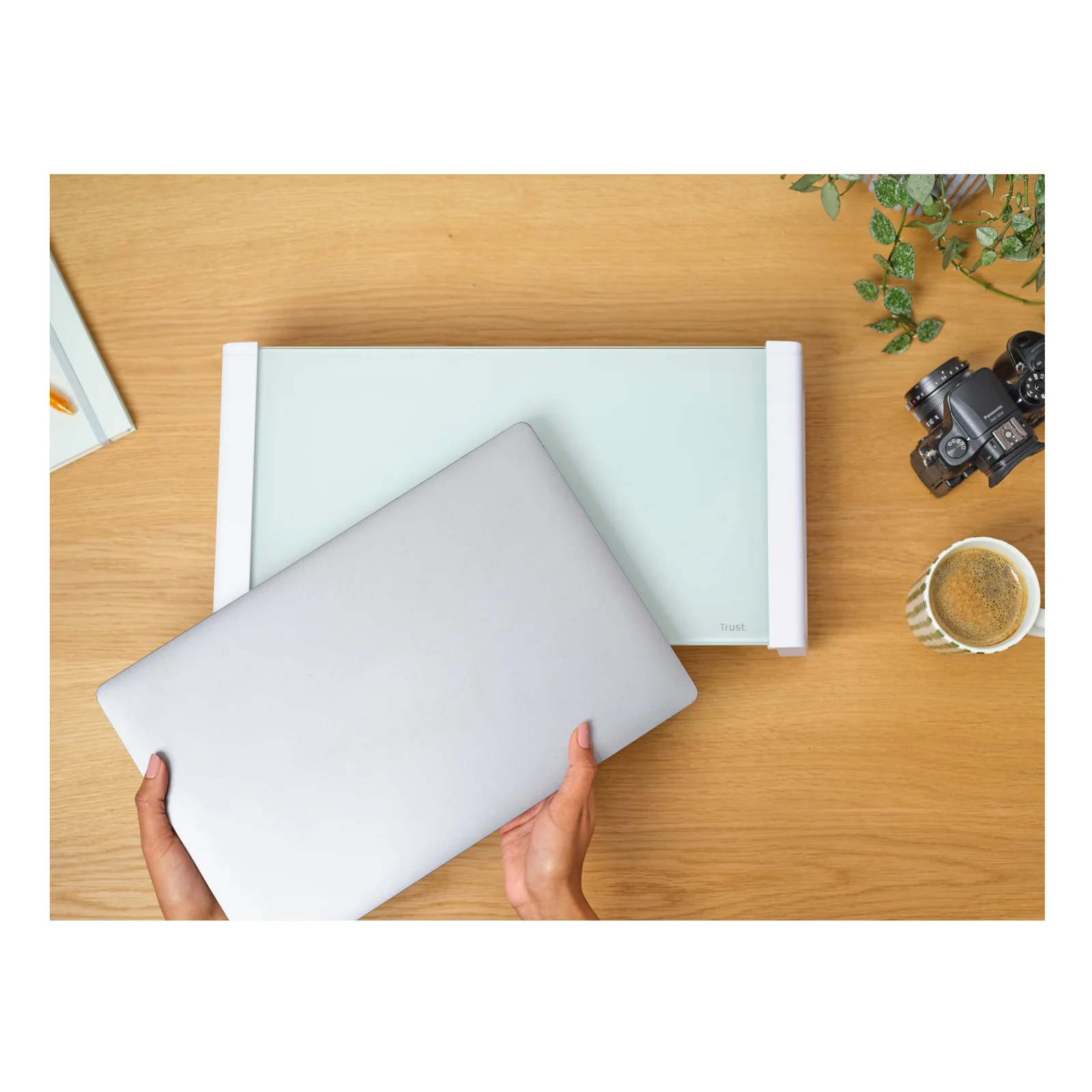 Mains posant un ordinateur portable sur la plateforme en verre du support Monta
