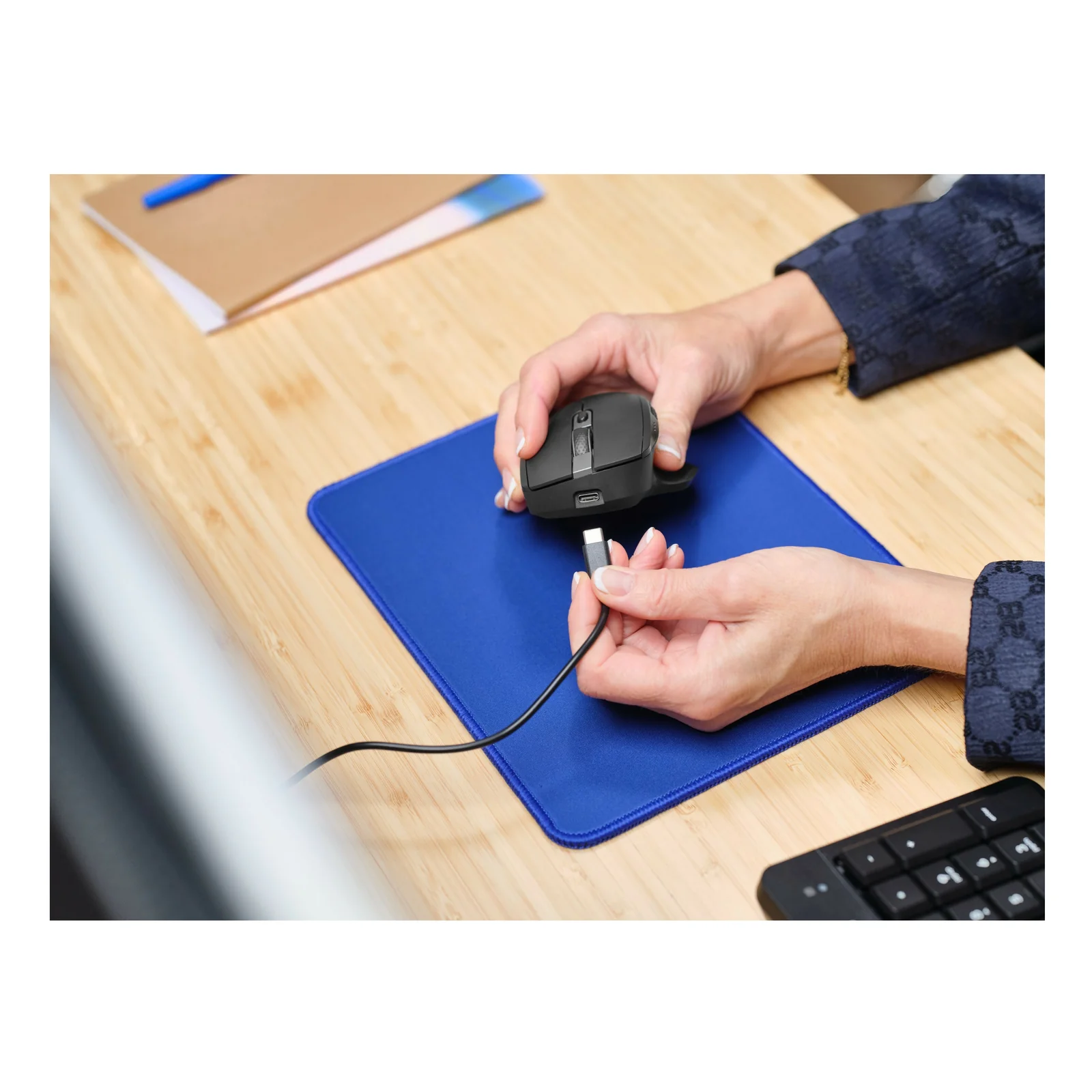 Dessous de la Trust Ozaa+ tenu en main, câble USB branché sur le port USB-C visible