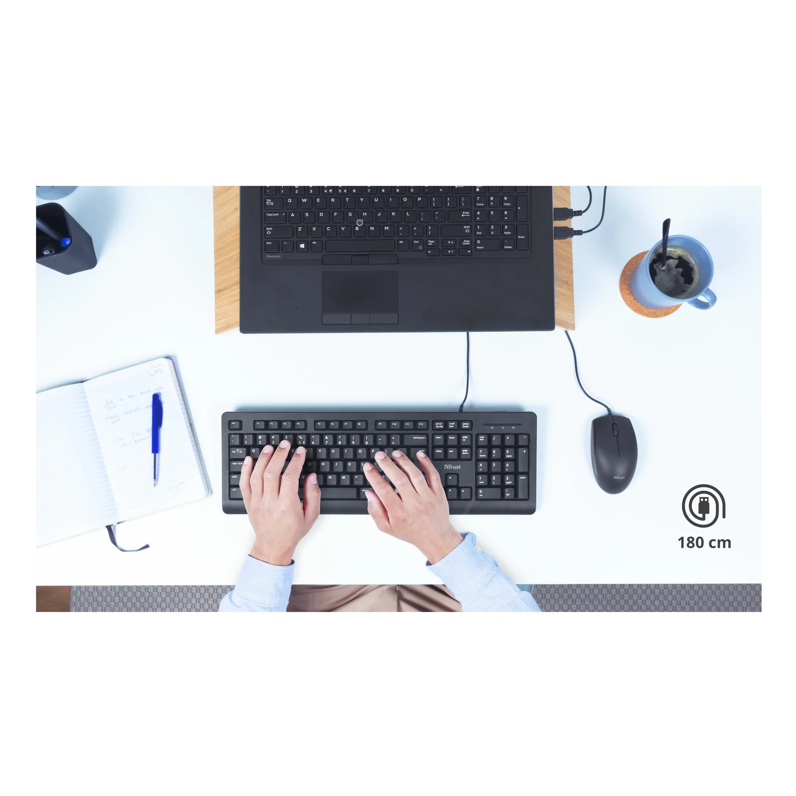 Vue du dessus, clavier Trust Primo noir sur bureau blanc, câble et pictogramme résistance à l'eau